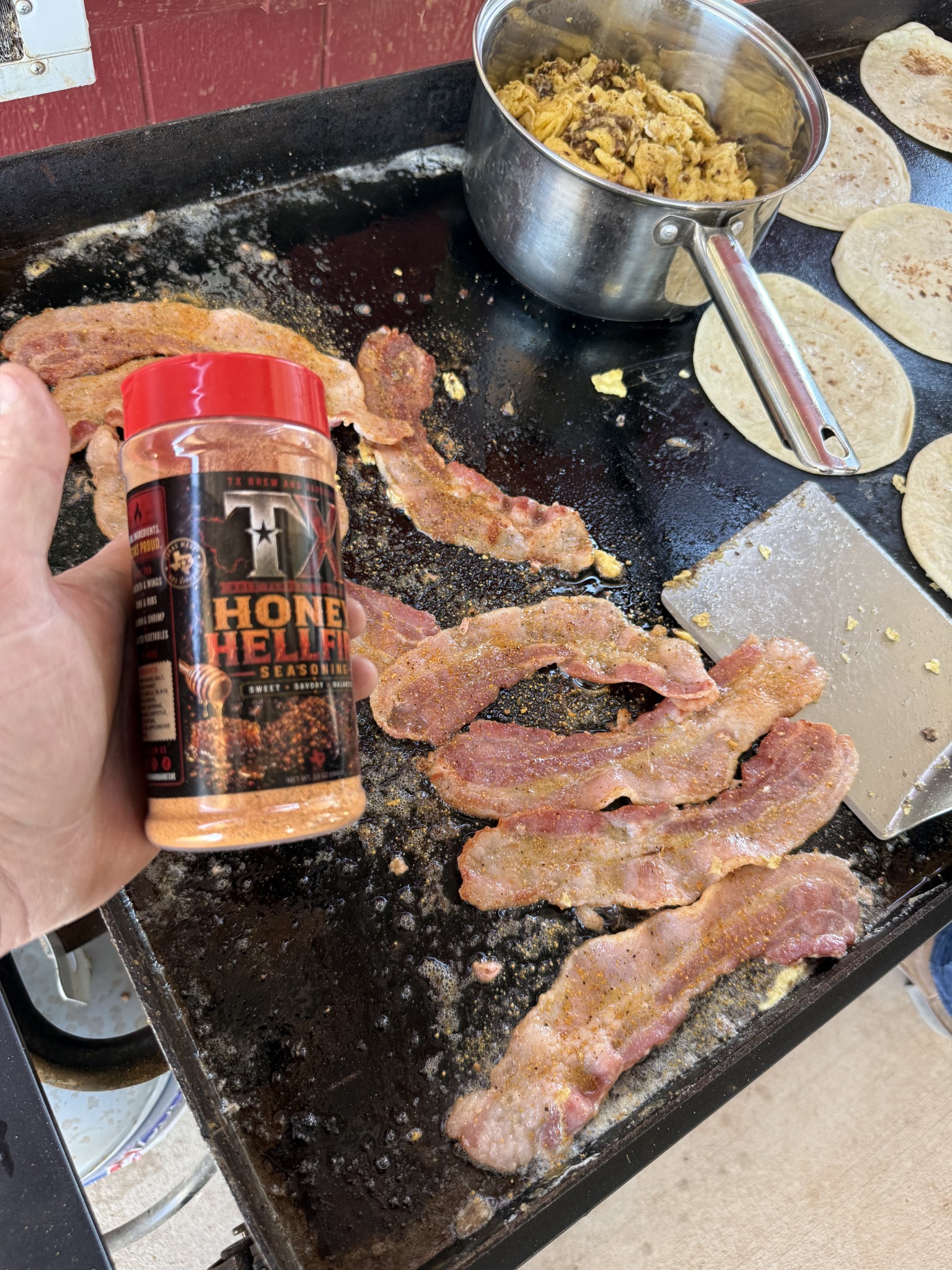 Honey Hellfire held over bacon, eggs and tortillas on a griddle